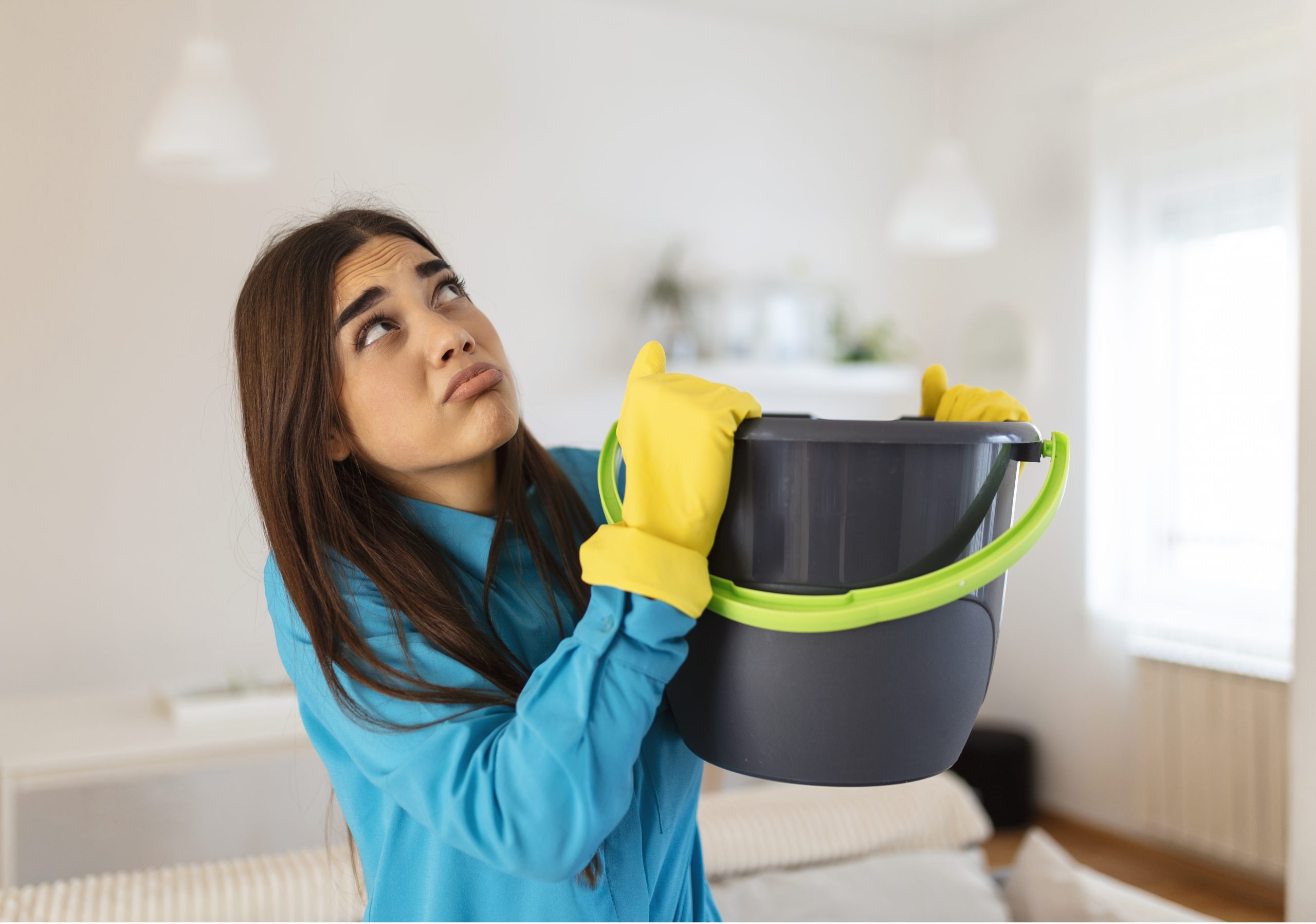 Water Damage Cleaning Contractor New York - A Woman Catching a Roof Leak in a Bucket