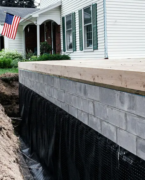 A House with a New Addition’s Foundation with Waterproof Coating Around the Bottom