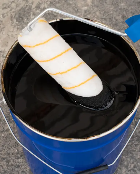 A Bucket of Waterproof Coating with a Roller Brush in it