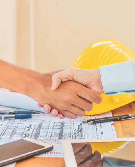 Spray Foam Insulation Contractors in Elmhurst, NY - Two Men Shaking Hands Over Construction Blueprints on a Table