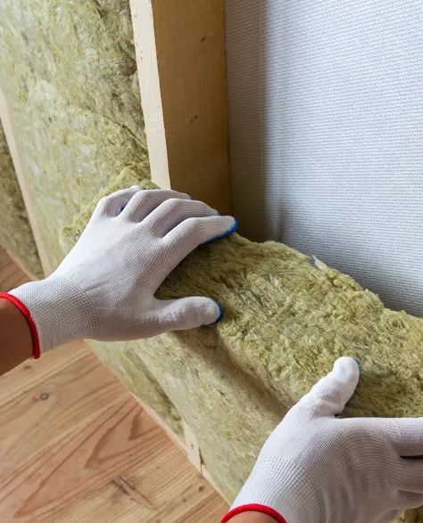 Spray Foam Insulation Contractors in Jackson Heights, NY - A Man Placing Insulation Between Two Studs