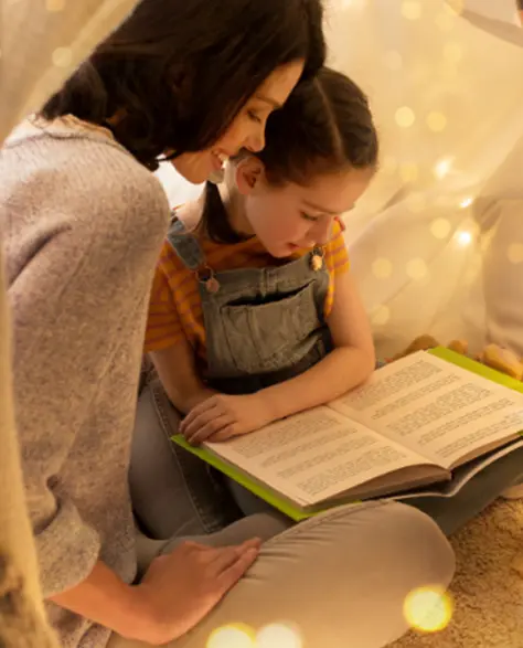 Spray Foam Insulation Contractors in Richmond Hill, NY - A Woman and Her Little Girl Reading a Book with Christmas Lights and Sheets Making a Tent Around them