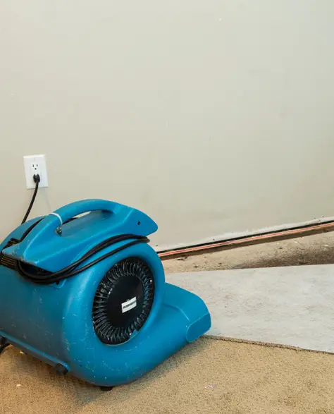 Water Damage Restoration Contractors in Baldwin, NY - Commercial Fans Drying a Corner of a Room with Water Intrusion<br />

