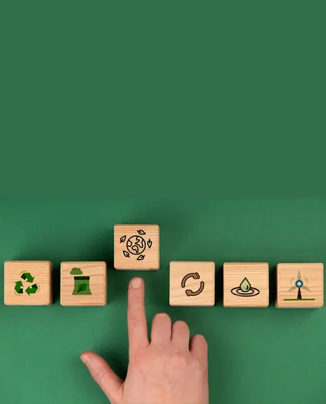 Spray Foam Insulation Contractors in Douglaston–Little Neck, NY - A Man’s Hand Pointing to Small Wooden Blocks with Energy Efficient Icons on Them