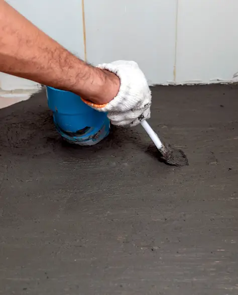 Foundation Contractors in Long Island, NY - Waterproof Coating Being Applied to a Basement Floor