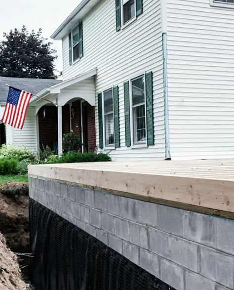 Foundation Contractors in Long Island, NY - A Picture of a Foundation with Waterproofing Barrier Applied<br />
