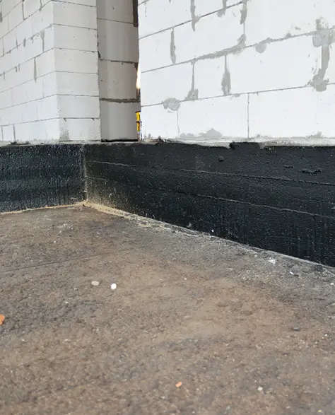 Water Damage Restoration Contractors in Freeport, NY - A Black Wall with a White Brick On it
