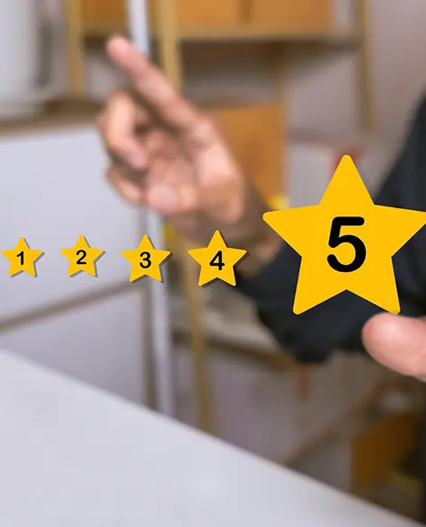 Water Damage Restoration Contractors in Glen Cove, NY - A Man Sitting at His Kitchen Table Doing a Five-star Review With Gold Stars in the Air
