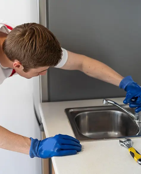 Water Damage Restoration Contractors in Glen Cove, NY- A Water Damage Repair Technician Working on a Sink That's Leaking