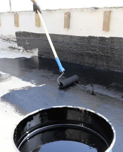 Water Damage Restoration Contractors in Hicksville, NY -  A man waterproofing a black surface with a roller