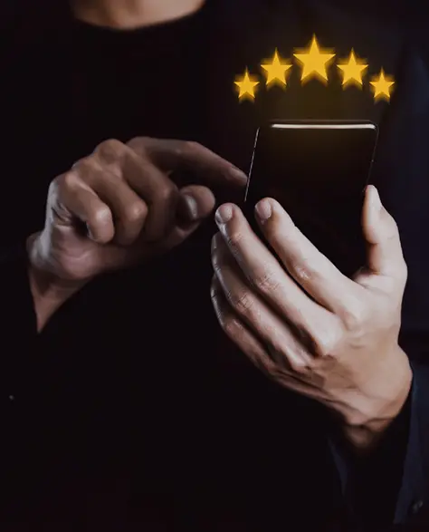 Water Damage Restoration Contractors in Medford, NY - A Man Giving a Review On His Smartphone with Five Gold Stars in the Air Above it