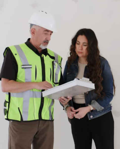 Water Damage Restoration Contractors in Park Slope, NY - A Man with a Hardhat and a Clipboard Explaining Something to a Homeowner