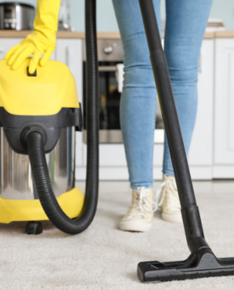 Water Damage Restoration Contractors in Shirley, NY - A Woman with a Wet Dry Vac on Her Carpet
