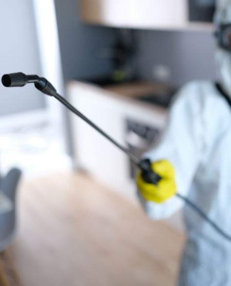 Water Damage Restoration Contractors in Shirley, NY - A Man in a Full Protective Suit Holding a Spray Gun