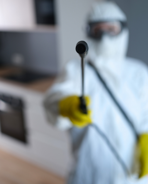 Water Damage Restoration Contractors in Smithtown, NY - A Man in a Full Protective Suit Holding a Spray Gun