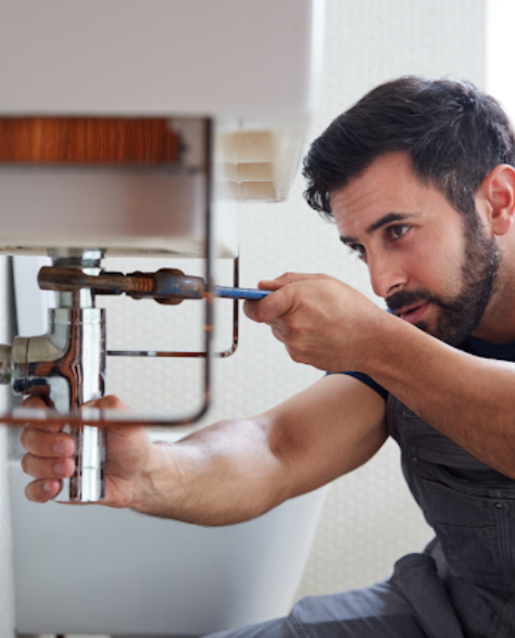 Water Damage Restoration Contractors in Corona, NY - A plumber fixing a leaking sink pipe<br />
