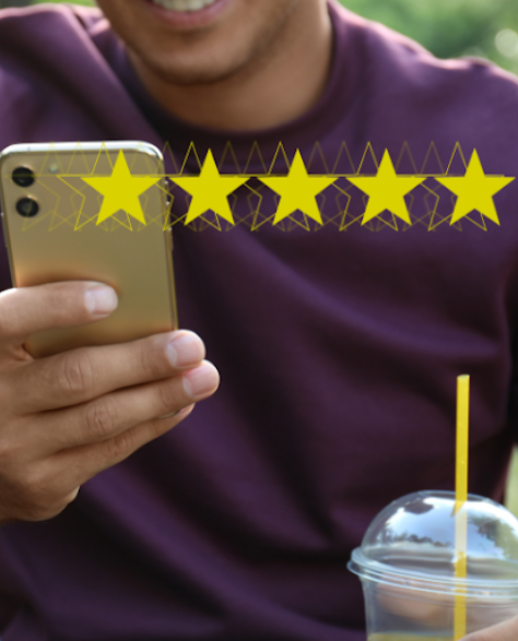 Water Damage Restoration Contractors in East Elmhurst, NY - A Man in the Park Holding His Phone and a Drink with Five Stars Above it<br />
