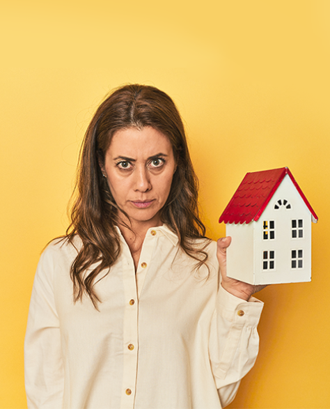 Water Damage Restoration Contractors in Forest Hills, NY - A Lady Holding a House Model Looking Confused<br />
