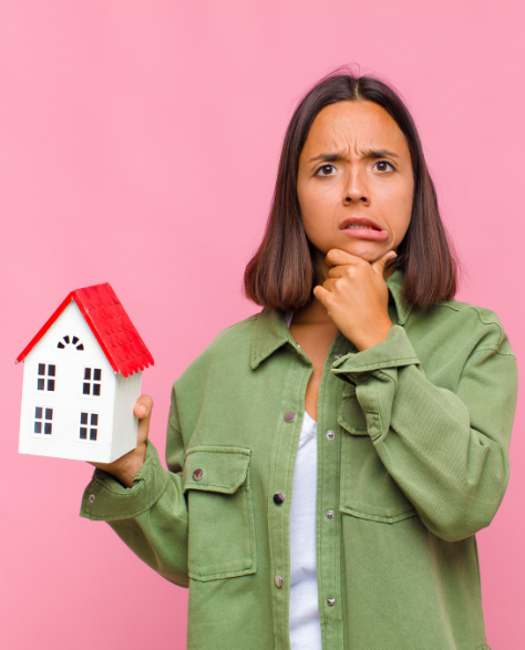 Water Damage Restoration Contractors in Fresh Meadows, NY - A Woman Holding a House Model Looking Confused<br />
