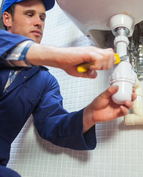 Water Damage Restoration Contractors in Fresh Meadows, NY - A Water Damage Repair Technician Fixing a Water Leak Under the Sink<br />
