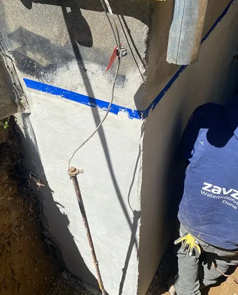 Foundation Repair Contractors in Floral Park, NY - A Zavza Seal Foundation Repair Technician Wearing a Company Branded Hoodie Working on a Foundation