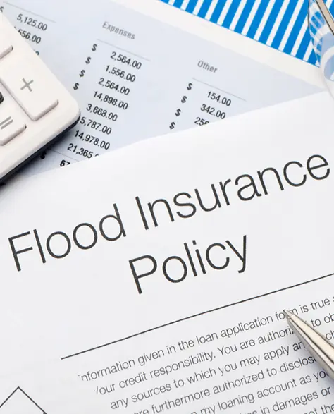 Water Damage Restoration Contractors in Lindenhurst, NY - A Paper Showing a Flood Insurance Policy With a Keyword on One Side and a Pen on the Other.
