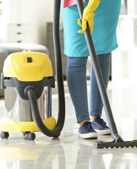 Water Damage Restoration Contractors in Deer Park, NY - A Woman with a Wet Dry Vac Vacuuming the Floor