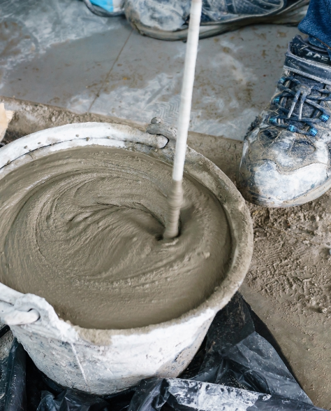 Foundation Repair Contractors in Brentwood, NY - A Man Mixing Cement in a Bucket<br />
