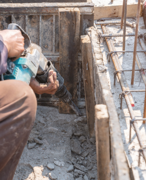 Foundation Repair Contractors in Commack, NY - A Man Using Power Tools to Work on a Foundation<br />
