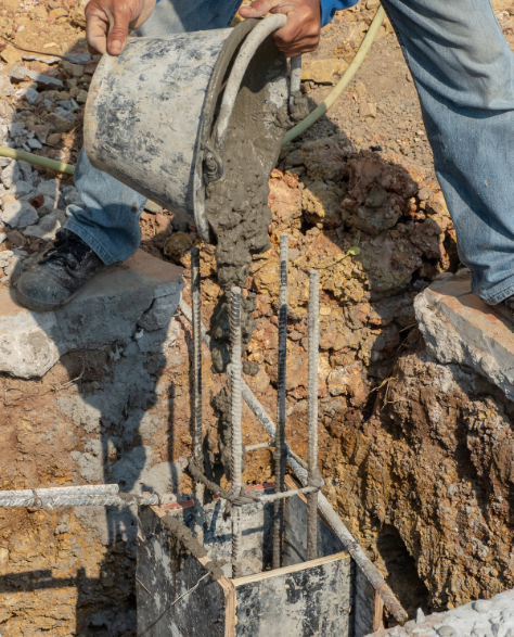 Foundation Repair Contractors in Coram, NY - A Man Pouring Cement into a Foundation Column