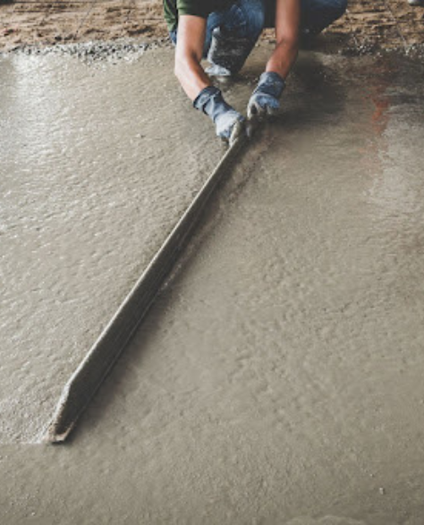 Foundation Repair Contractors in Coram, NY - A Man Using a Large Trowel to Float Cement<br />
