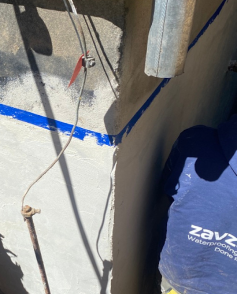 Foundation Repair Contractors in Freeport, NY - A Zavza Seal Foundation Crack Repair Specialist with a Zavza Seal Branded Hoodie Working on a Foundation<br />
