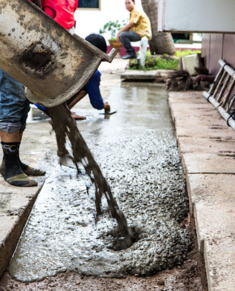 Foundation Repair Contractors in Brooklyn Heights, NY - Men Pouring Cement Outside a House Near the Foundation