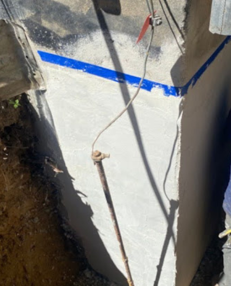 Foundation Repair Contractors in Massapequa, NY -  A Zavza Seal Foundation Cracks Repair Technician Wearing a Company Branded Sweatshirt Standing by the Foundation on a Project<br />
