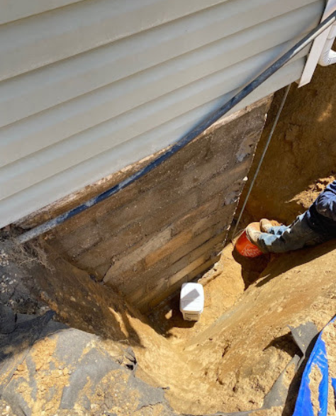 Foundation Repair Contractors in Medford, NY - A Zavza Seal Foundation Repair Specialist Wearing Company Branded Hoodie Working On a Foundation<br />
