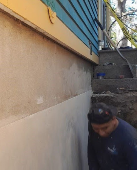 Foundation Repair Contractors in Plainview, NY - A Zavza Seal Foundation Repair Specialist Wearing a Company Branded Sweatshirt Working on a Foundation<br />
