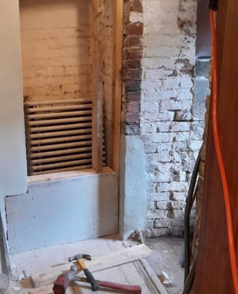 Foundation Repair Contractors in Plainview, NY - A Brick Wall with Foundation Damage-Related Damage and Some Tools Sitting Beside it<br />

