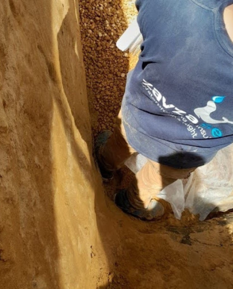 Foundation Repair Contractors in Selden, NY - Zavza Seal Foundation Repair Specialist Working on a Foundation with a Company Branded Hoodie On<br />
