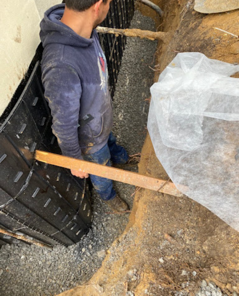 Top-Rated Foundation Repair Contractors in West Islip, NY - Zavza Seal's Foundation Repair Crew Wearing Company Branded Hoodies Working On a Foundation<br />
