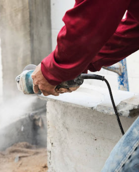 Top-Rated Foundation Repair Contractors in Smithtown, NY -  A Man Grinding Down a Foundation Support<br />
