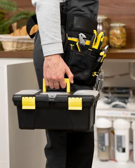 Water Damage Restoration Contractors in Queens Village, NY - A Man with a Toolbox Standing in Front of a Kitchen Sink