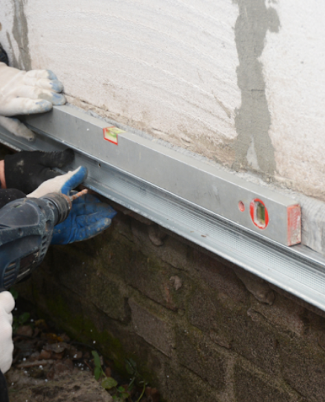 Foundation Repair Contractors in Valley Stream, NY - A Foundation Crack Repair Technician Working on a Foundation<br />
