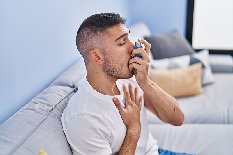 A man using an inhaler for his asthma