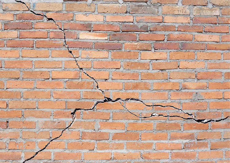 Bowing Basement Walls - A brick wall with a large crack in the center showing that the wall is bowing