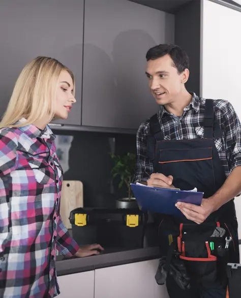 Water Damage Restoration Contractors in Woodside, NY - A Water Damage Restoration Technician Pointing Out Something On His Clipboard to Homeowners