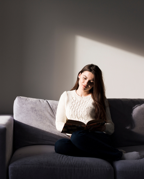 A woman relaxing in her soundproof home reading<br />
