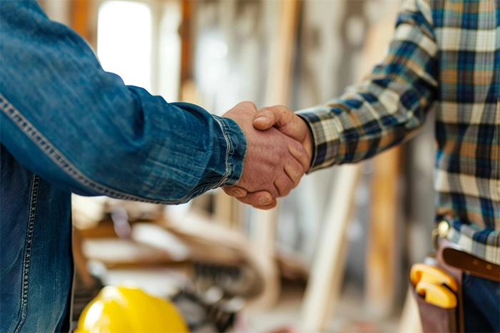 Foundation Repair, Insulation, Mold Remediation, and Waterproofing Contractors in Babylon, NY - A Homeowner Shaking Hands with a Construction Worker