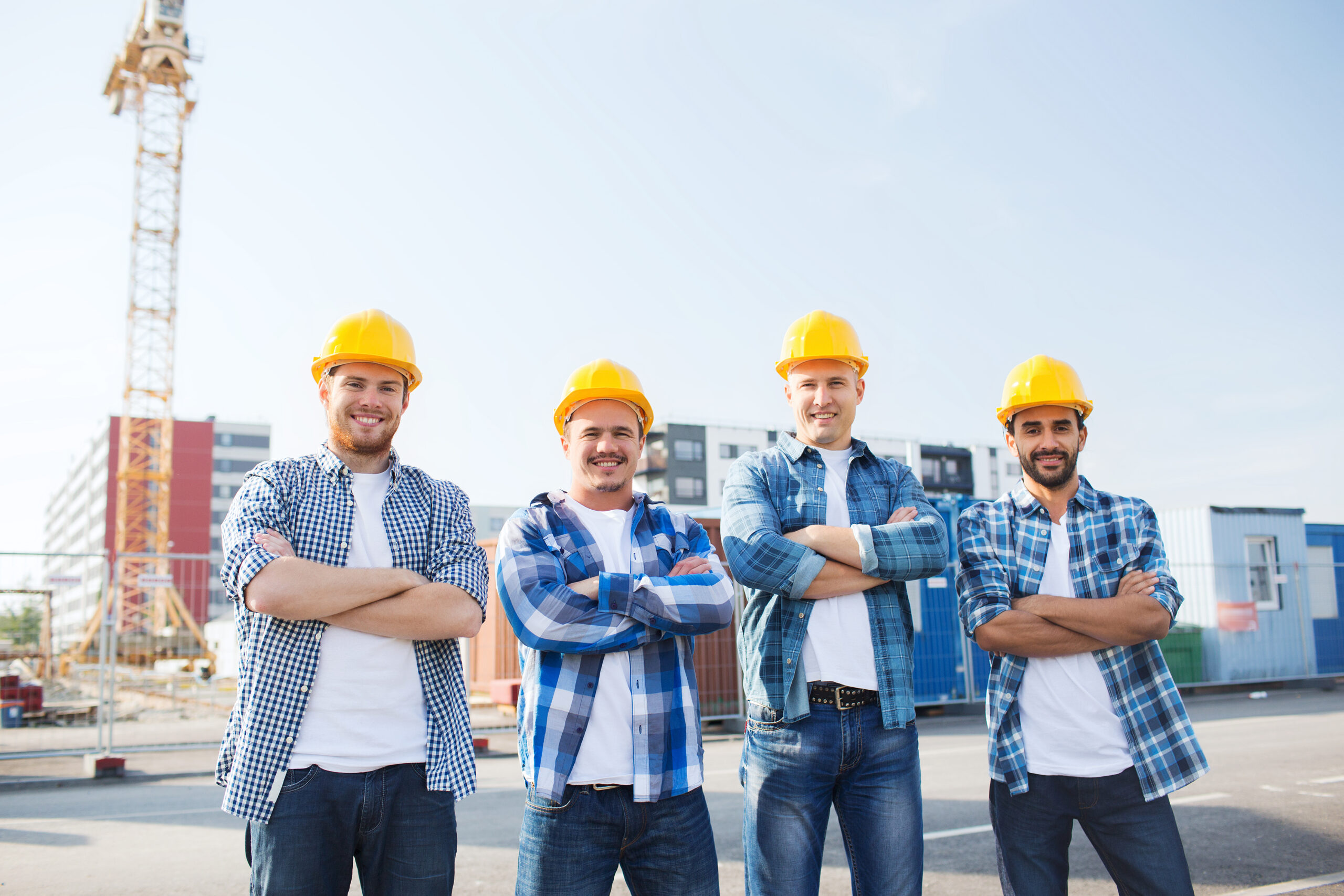 A team of experts from Zavza Seal llc standing together in hard hats and arms folded smiling to the camera