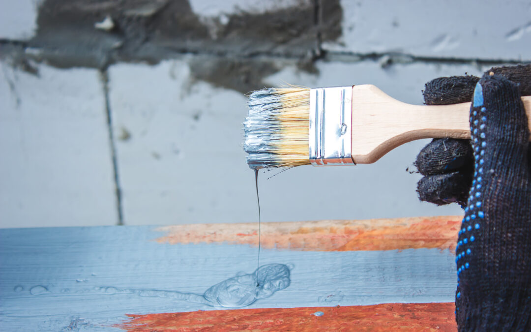 Application of crystalline waterproofing going on with a man holding a brush and applying it on the wall.