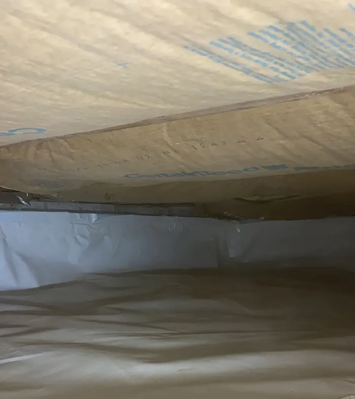 The crawl space after insulation and vapor barrier installation